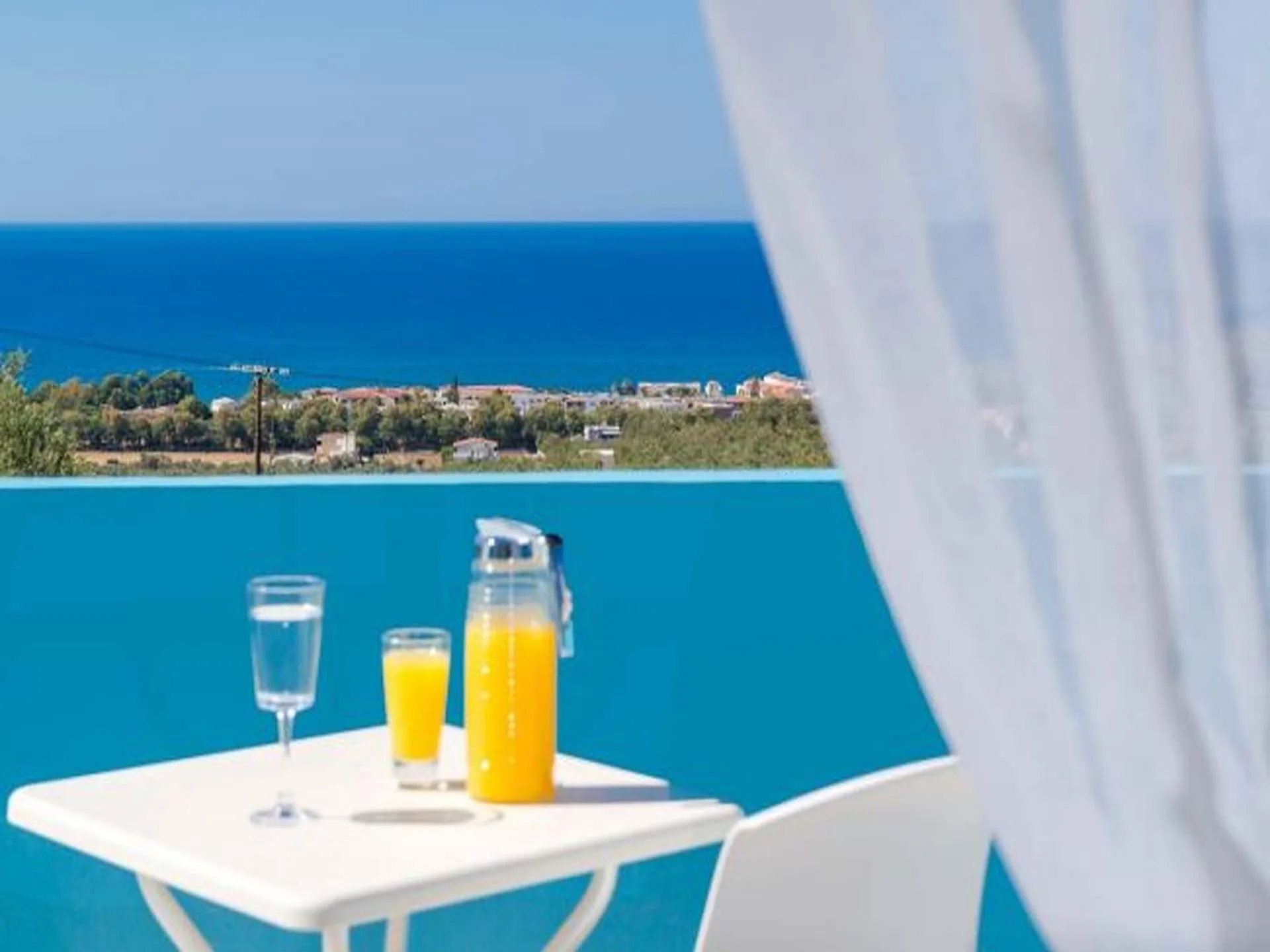 Breakfast set at a pool edge that dissolves into the sea below