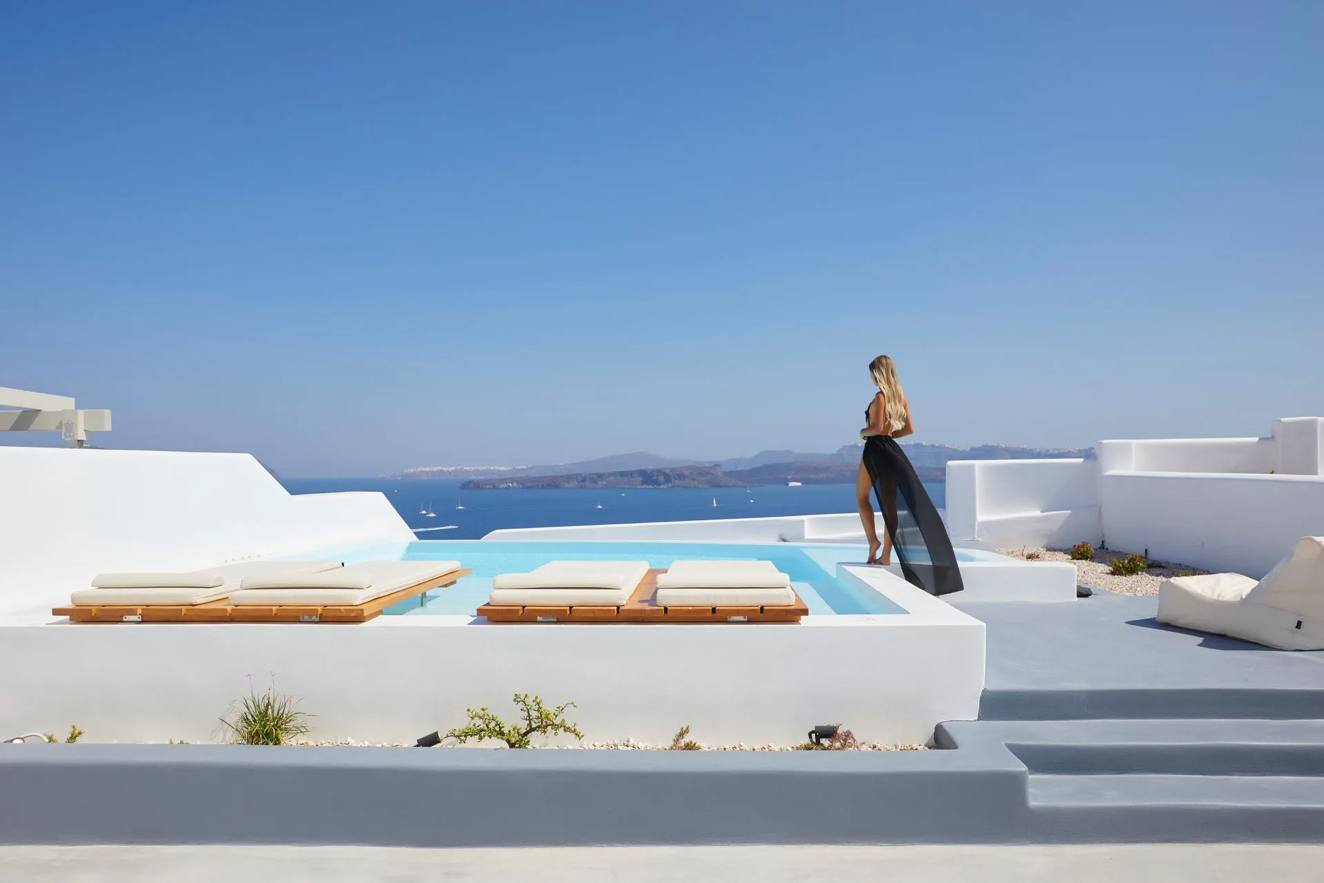 Looking out over the caldera and open sea from a villa terrace with an infinity pool