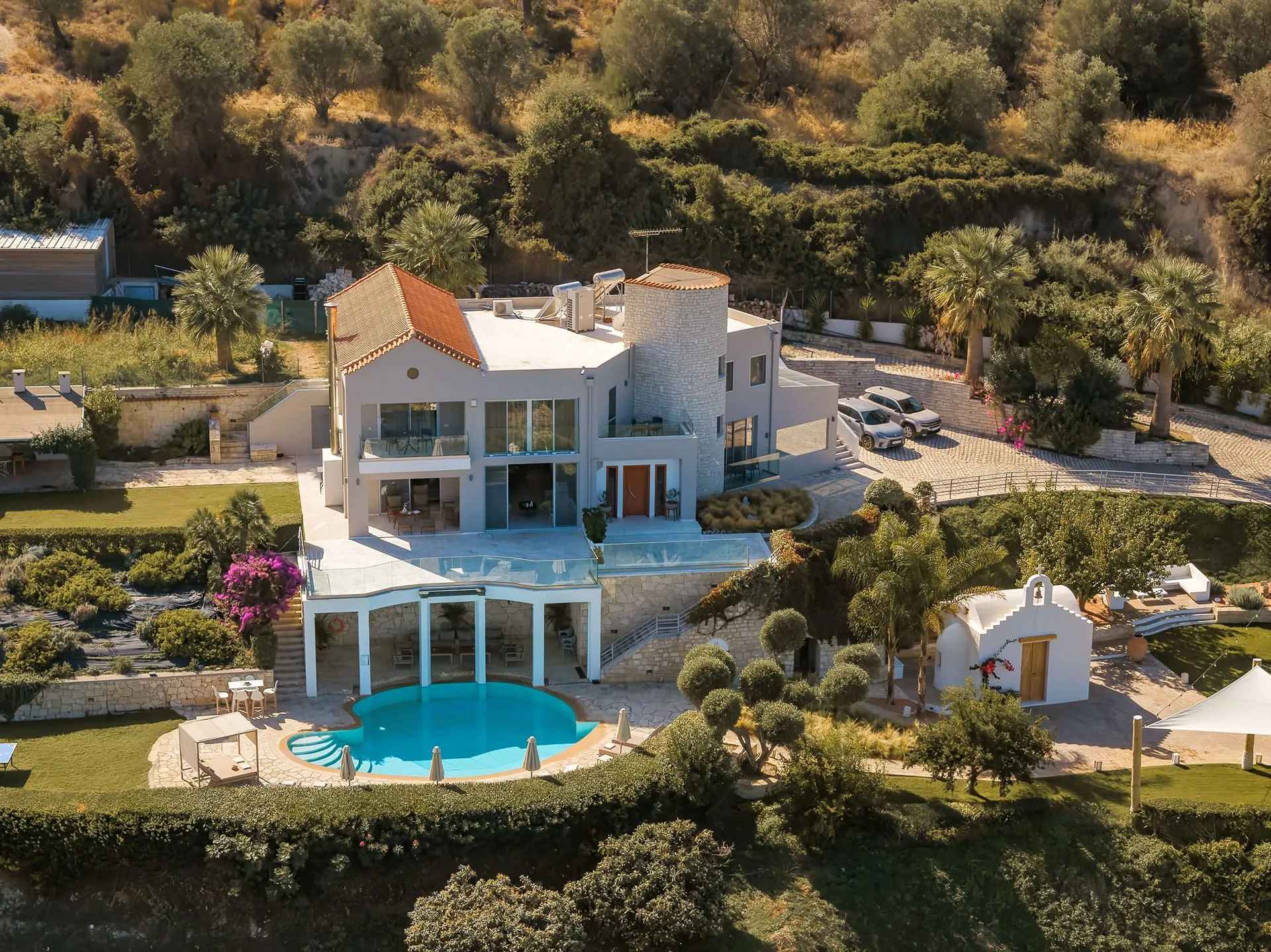 Lawns, a pool terrace and a private chapel in the grounds of a Cretan estate villa