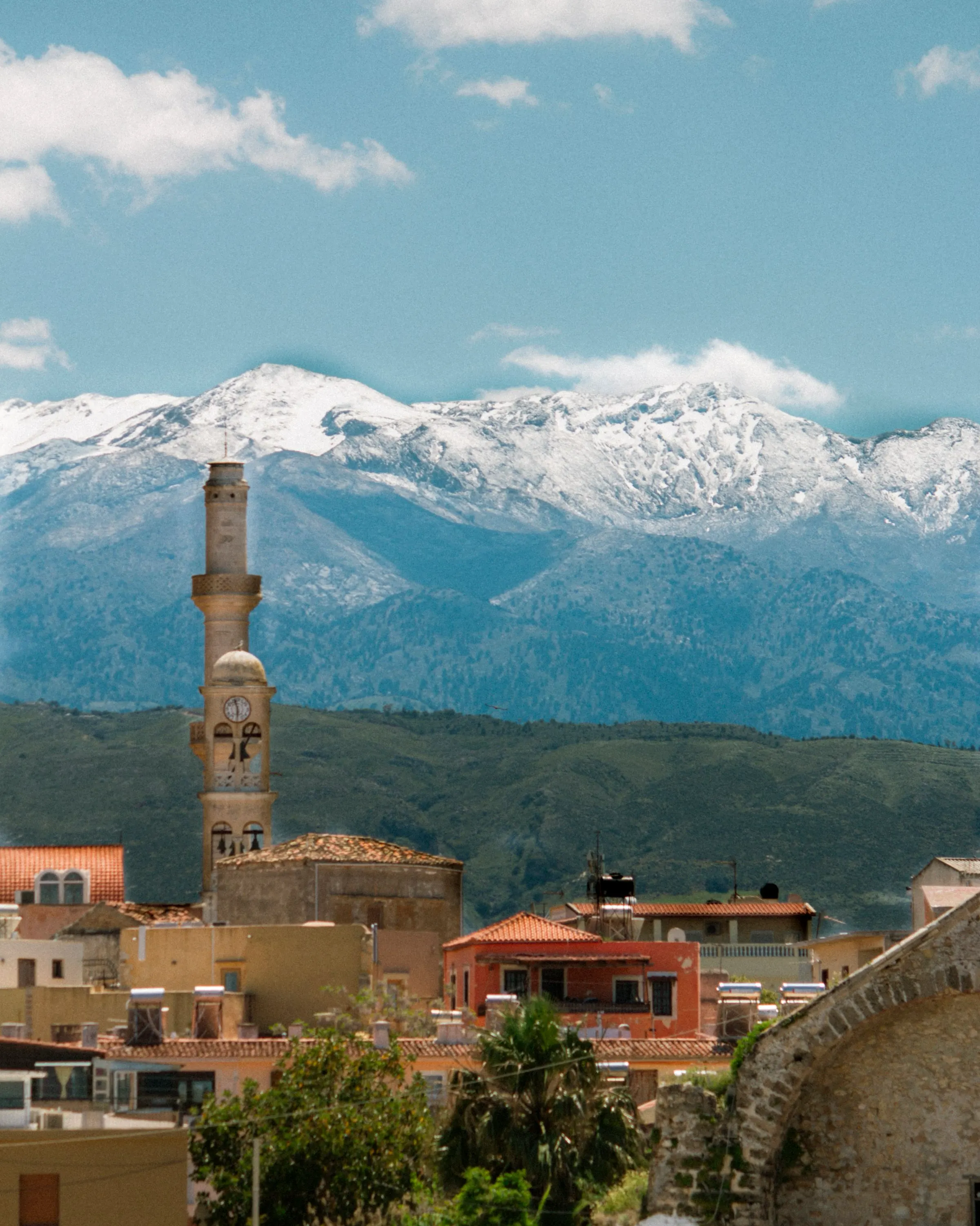 Snow-capped peaks of the White Mountains rising behind the rooftops of Chania