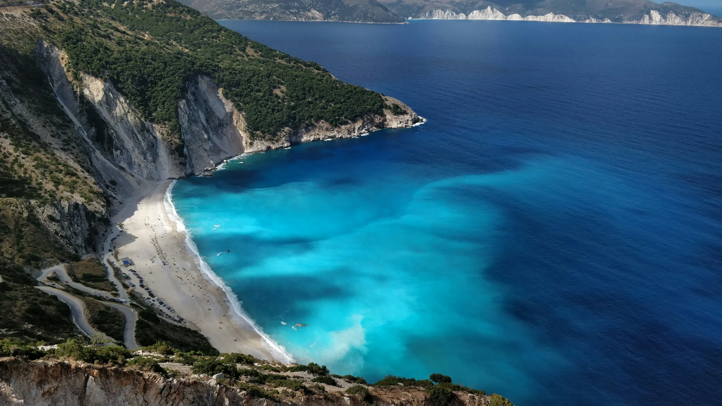 Myrtos beach from the cliff road above, white pebble between huge cliffs