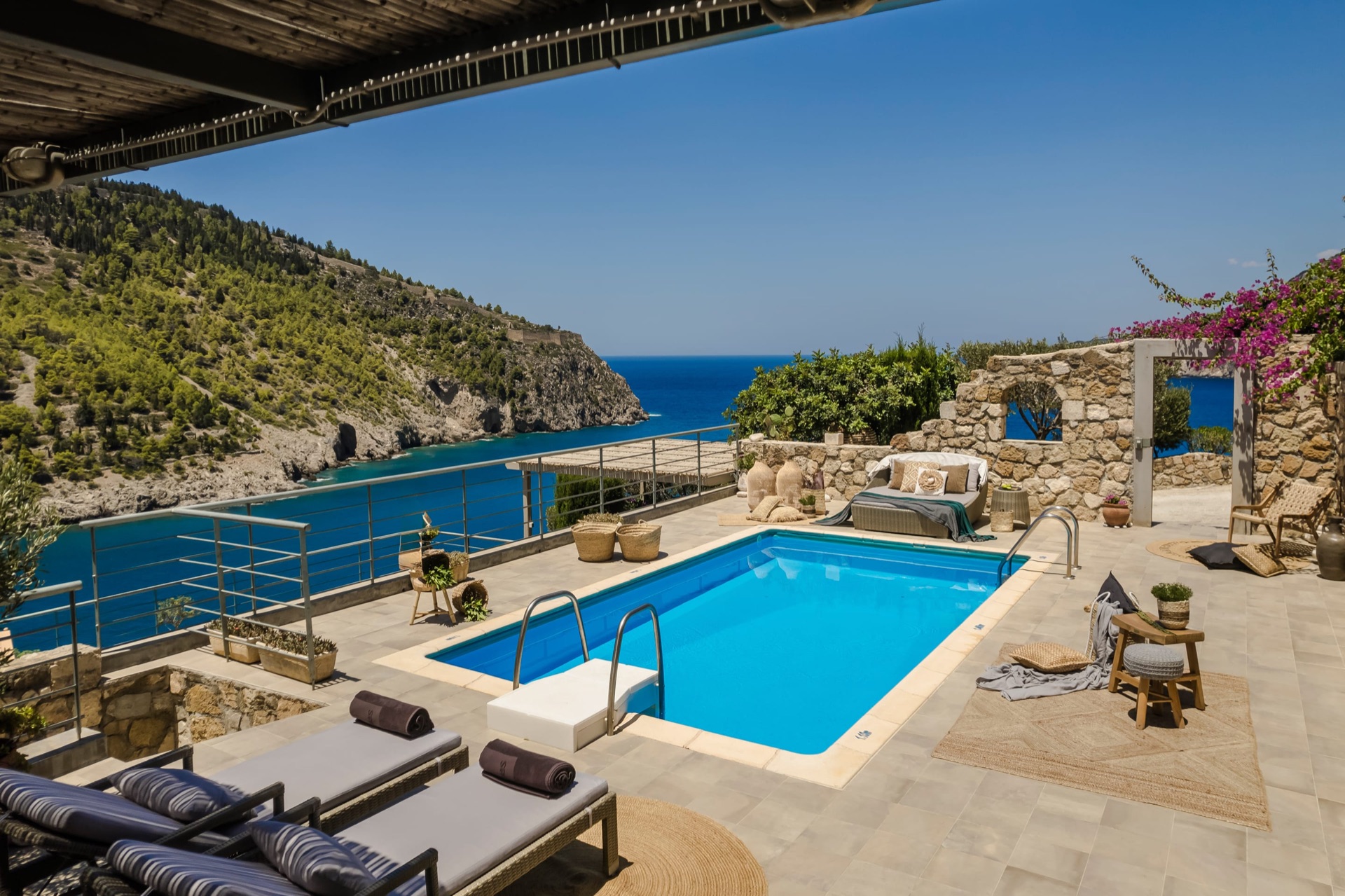 Private pool and stone garden walls at Villa Elea with the fortress headland beyond