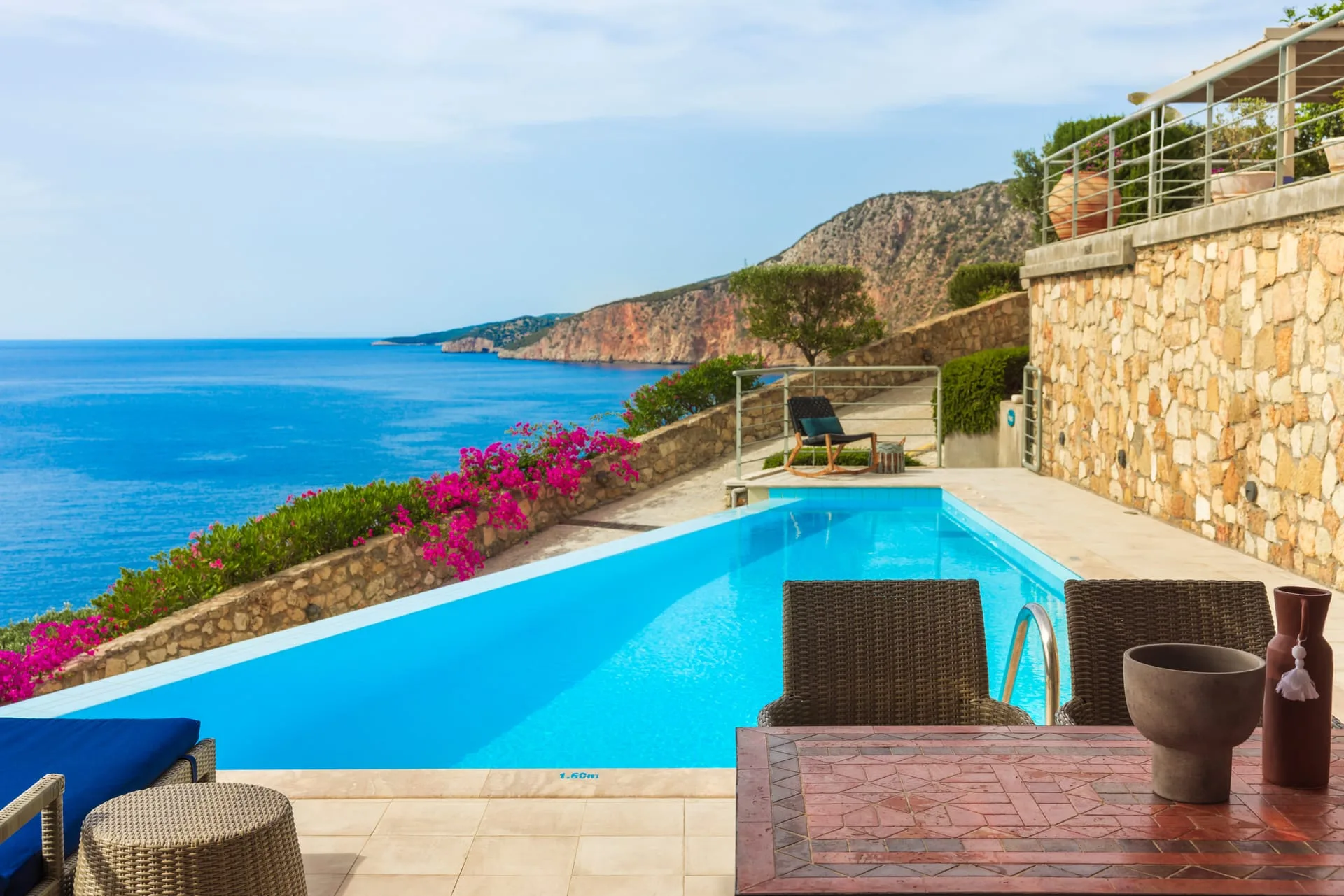Long private pool at Villa Prikonas with bougainvillea and coastal views
