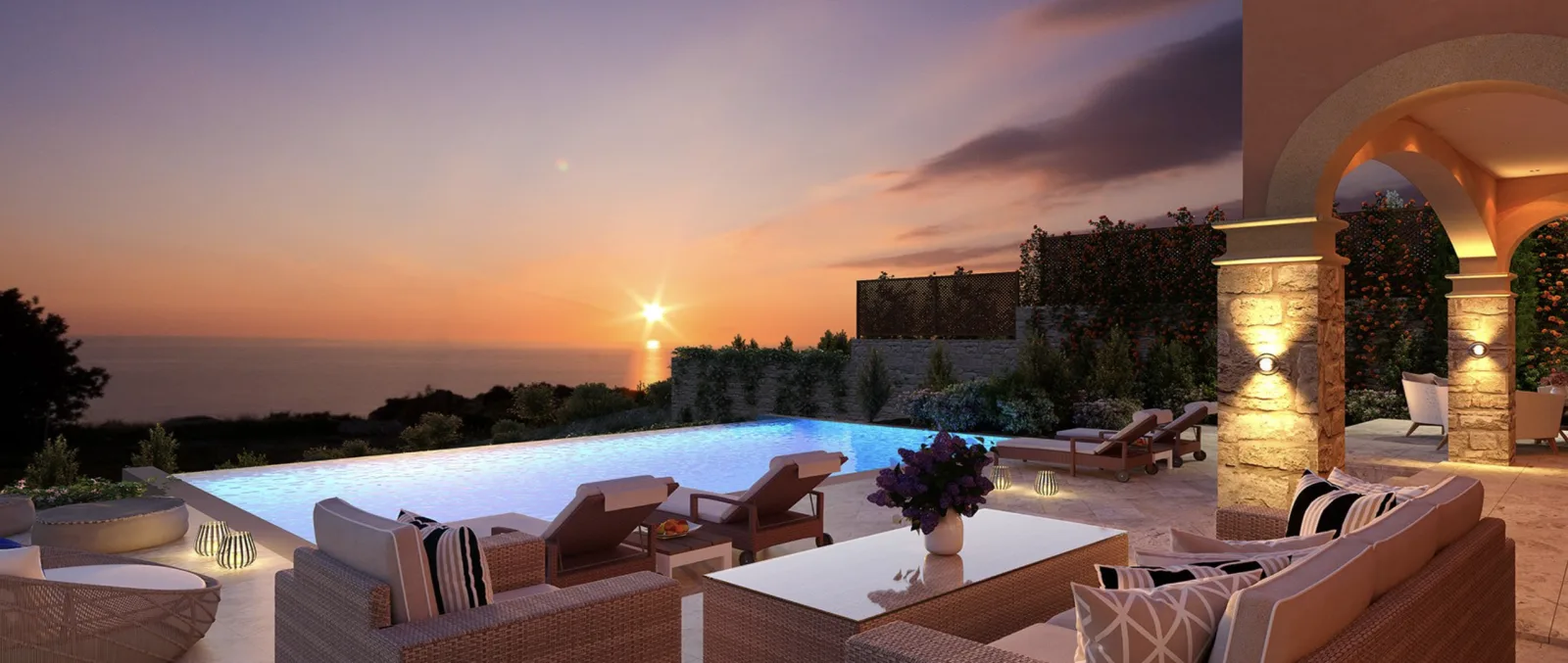 Sunset over the sea from a villa terrace lit by lanterns at Aphrodite Hills
