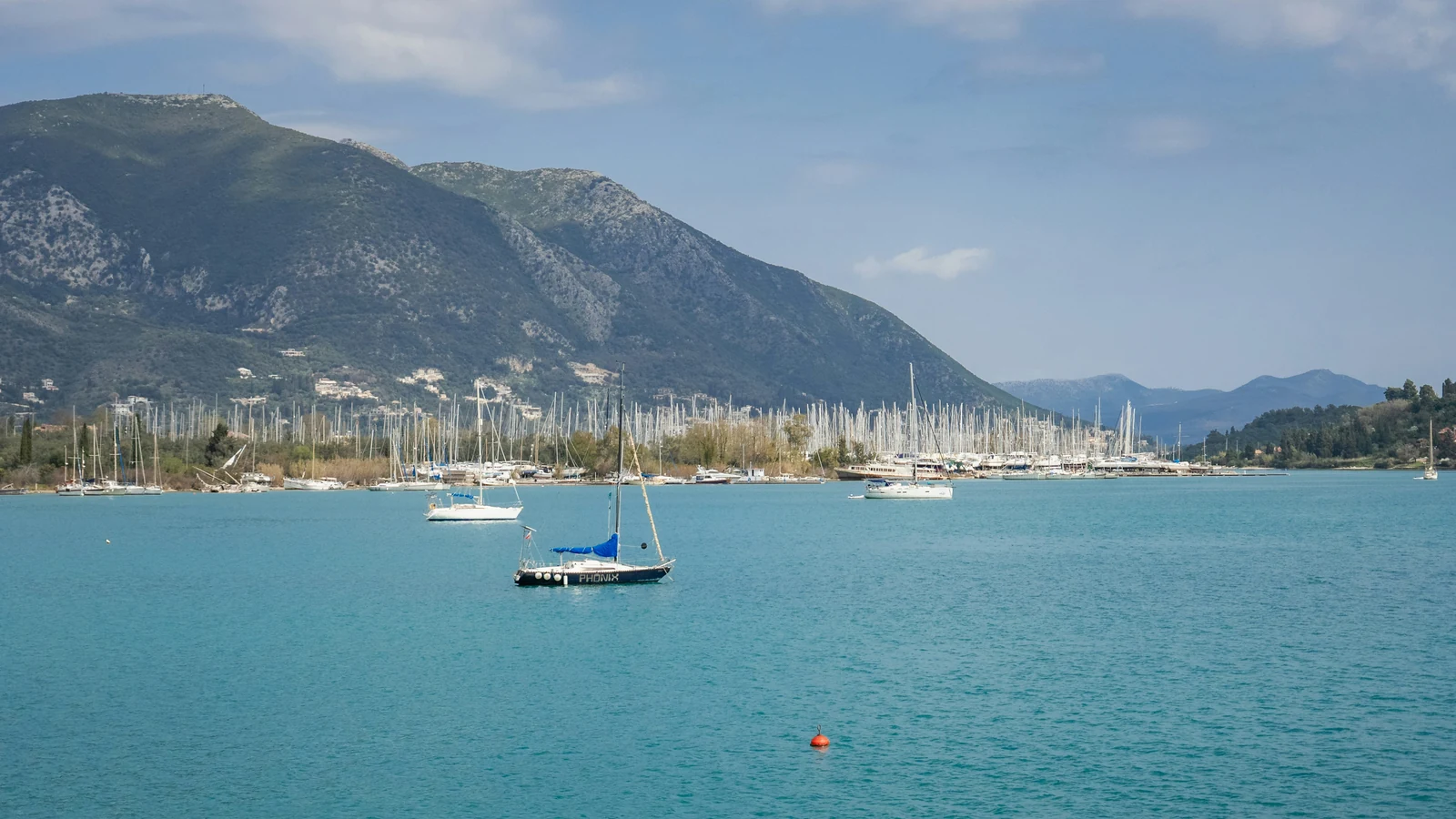 Sailing boats in Nydri Bay with Lefkada's green mountains behind