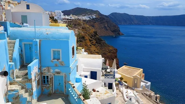 Blue-painted house and whitewashed steps above the Santorini caldera in spring