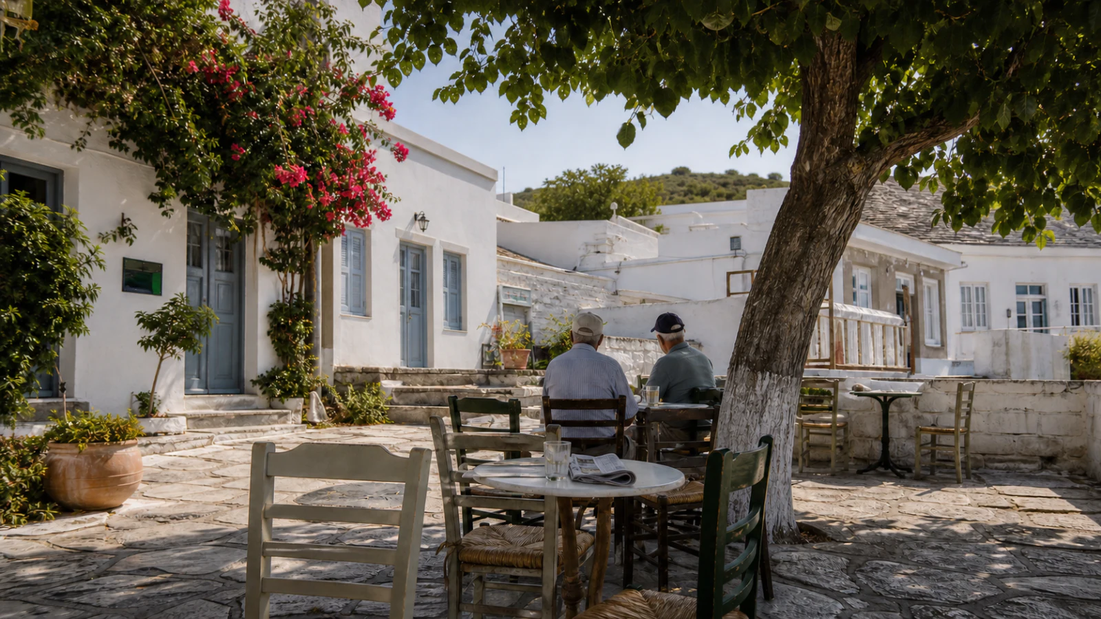 Two residents sitting at a shaded kafeneio in Lefkes village, Paros