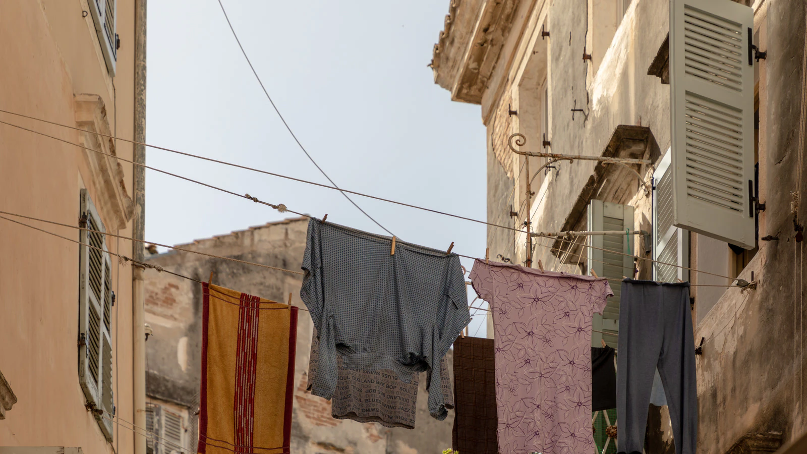 Laundry strung between weathered buildings in Corfu Old Town