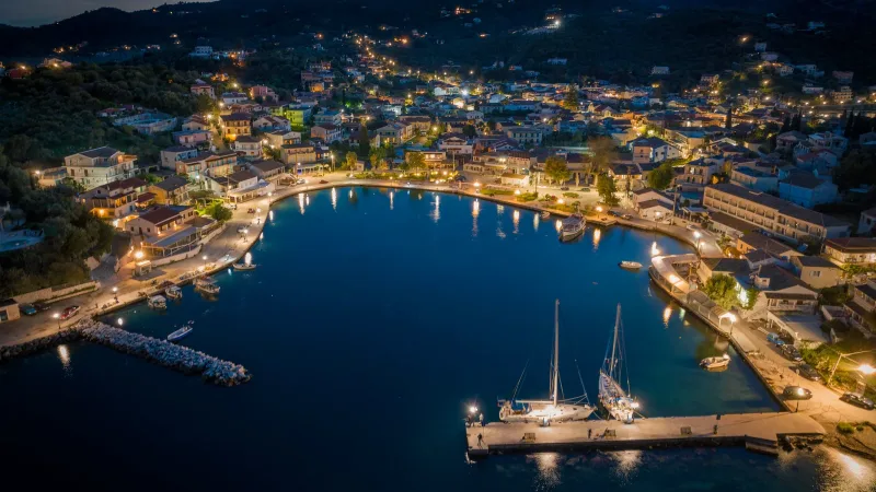 Kassiopi harbour and waterfront illuminated after dark in northern Corfu